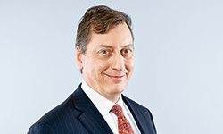 John R. Dacey – Group Chief Strategy Officer (photo)