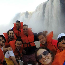 Employees in life vests on a boat in close proximity to a large waterfall (photo)