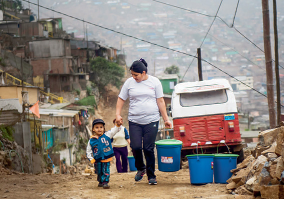 Women walking with her child in a low-income are in Lima, Peru. (photo)