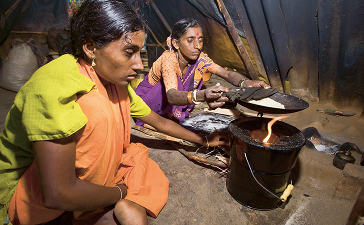 Village dwellers in India using a cooking stove (photo)