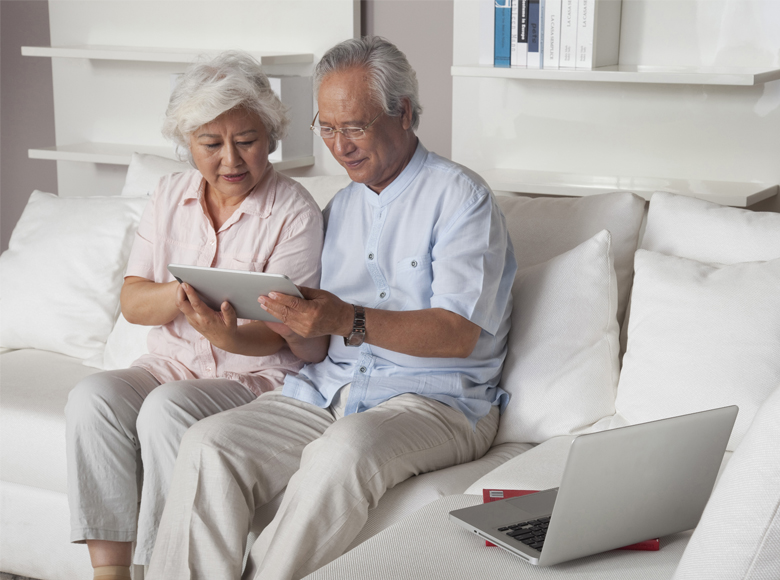 Two elderly people looking at a tablet (photo)